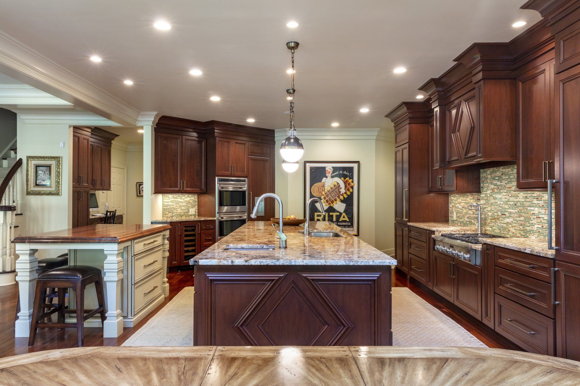 Spacious modern kitchen with dark wood cabinets, large island, and recessed ceiling lights