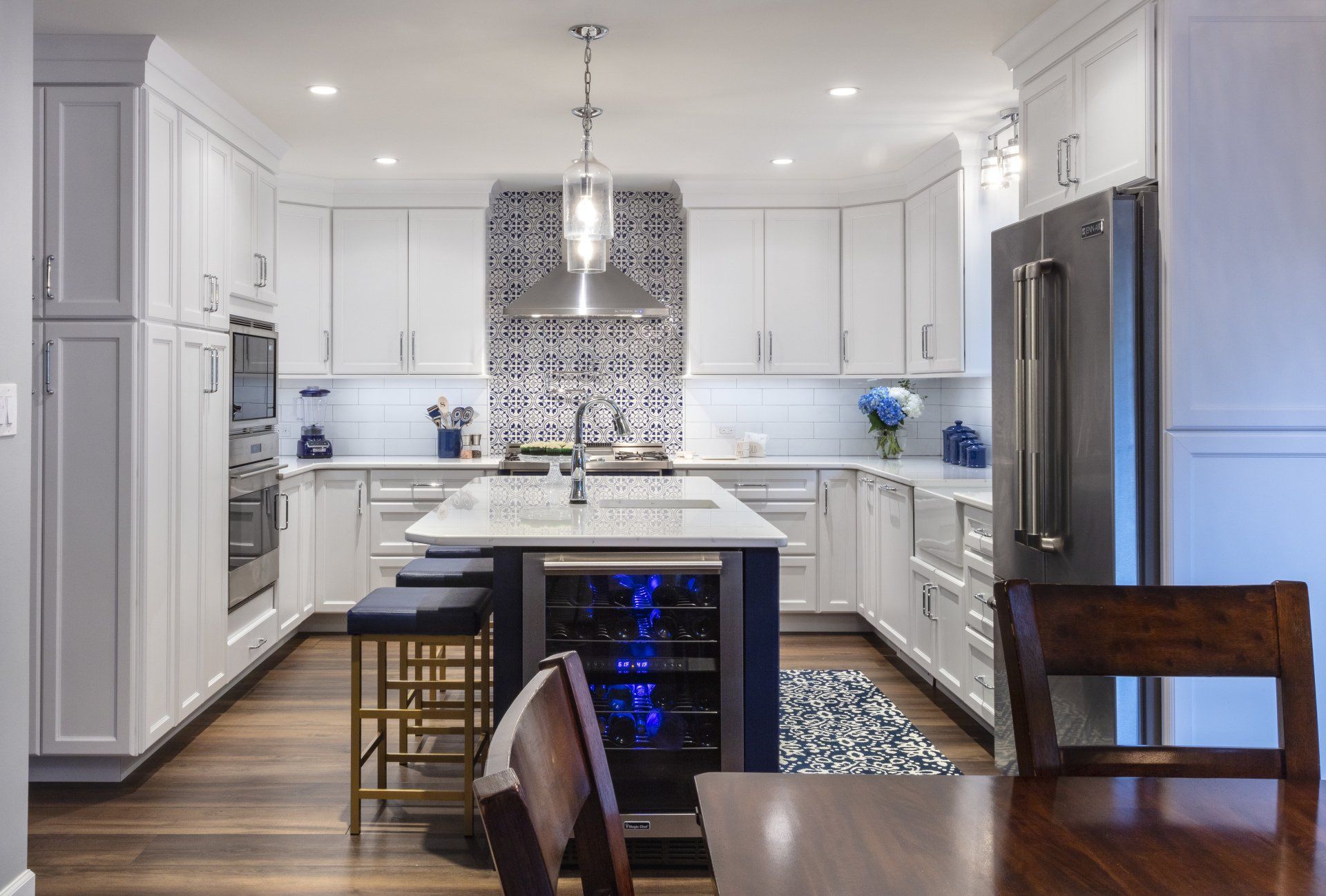 Bright modern kitchen with white cabinets, stainless steel fridge, island, and patterned backsplash