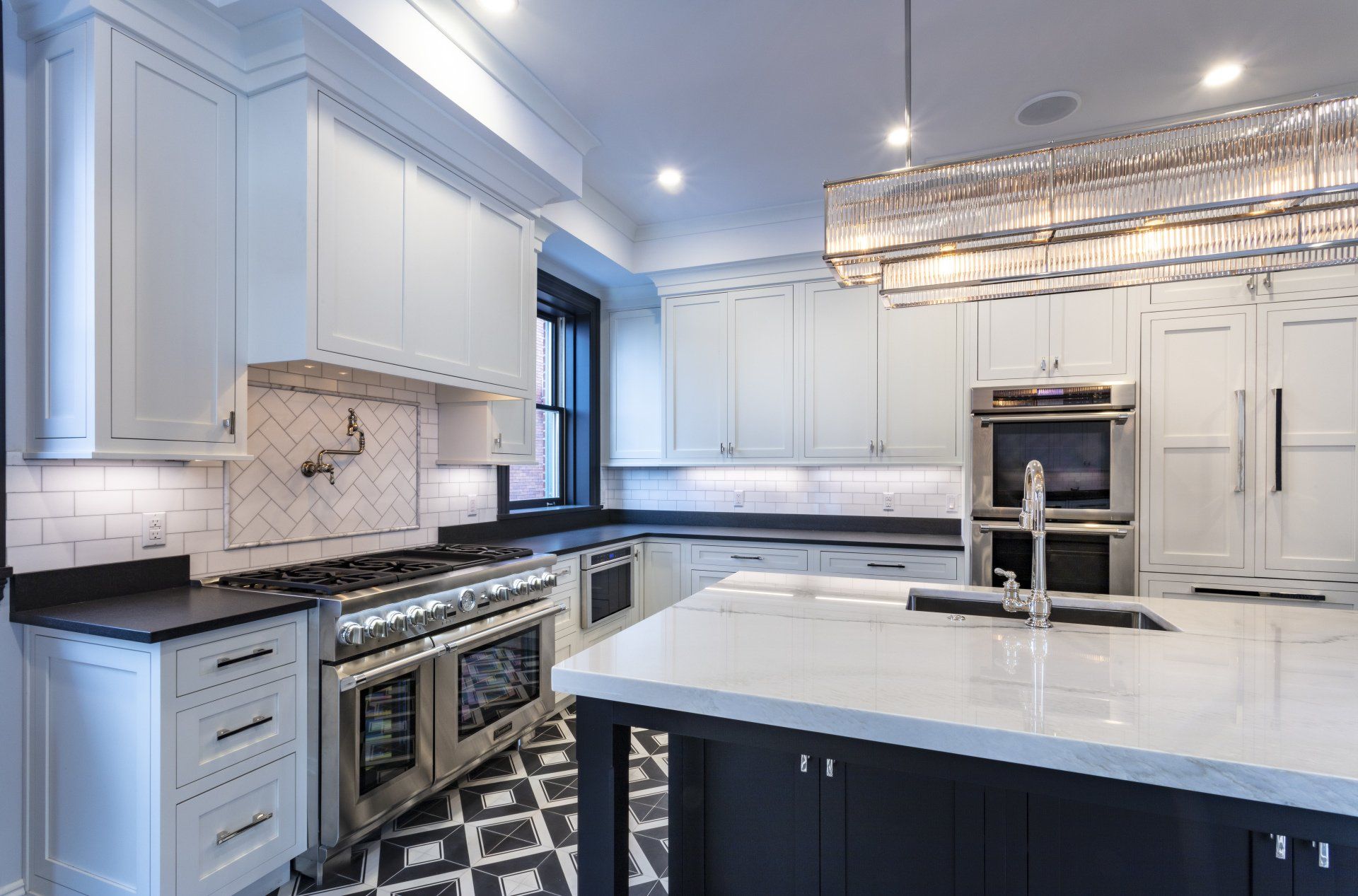 Bright modern white kitchen with large island, stainless appliances, and patterned black-and-white floor