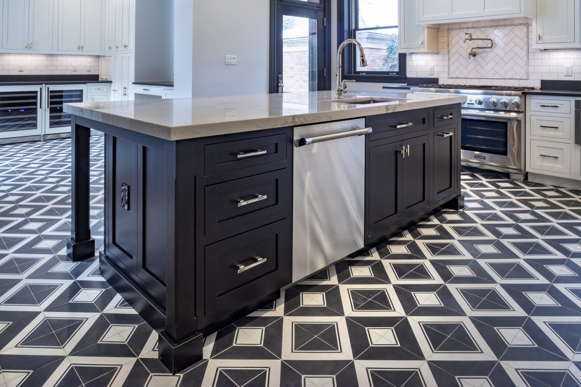 Modern kitchen with black island, white countertop, and geometric black-and-white tile floor