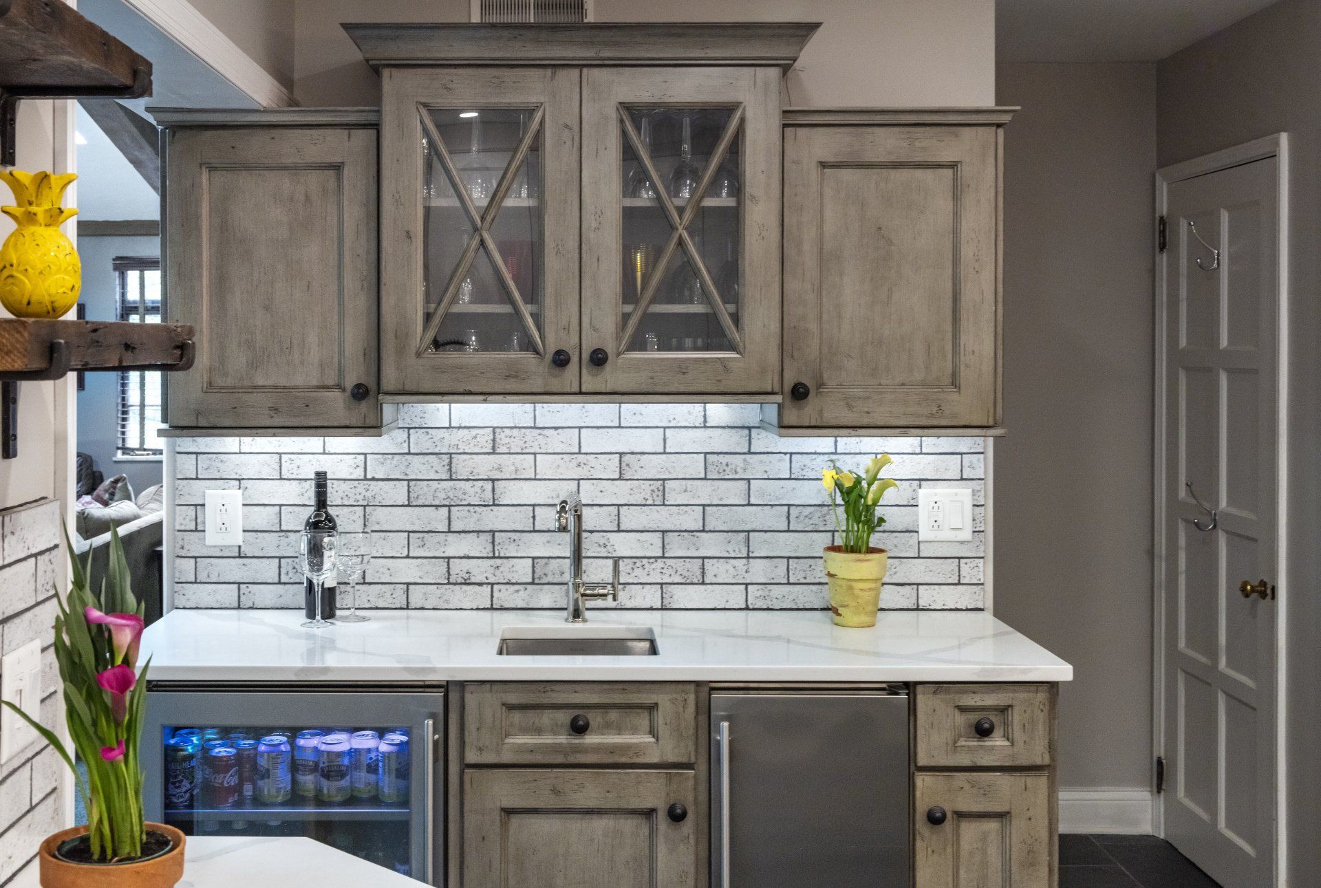 Modern kitchen with gray cabinets, white subway tile backsplash, and white countertops