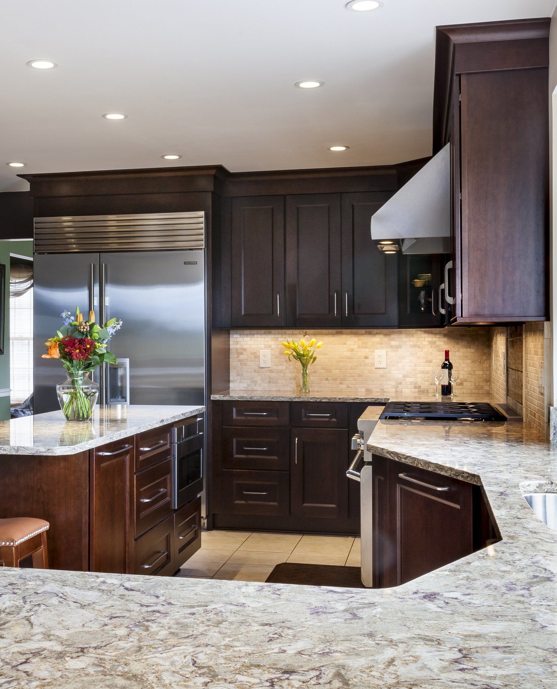 Modern kitchen with dark wood cabinets, stainless steel appliances, and granite countertops