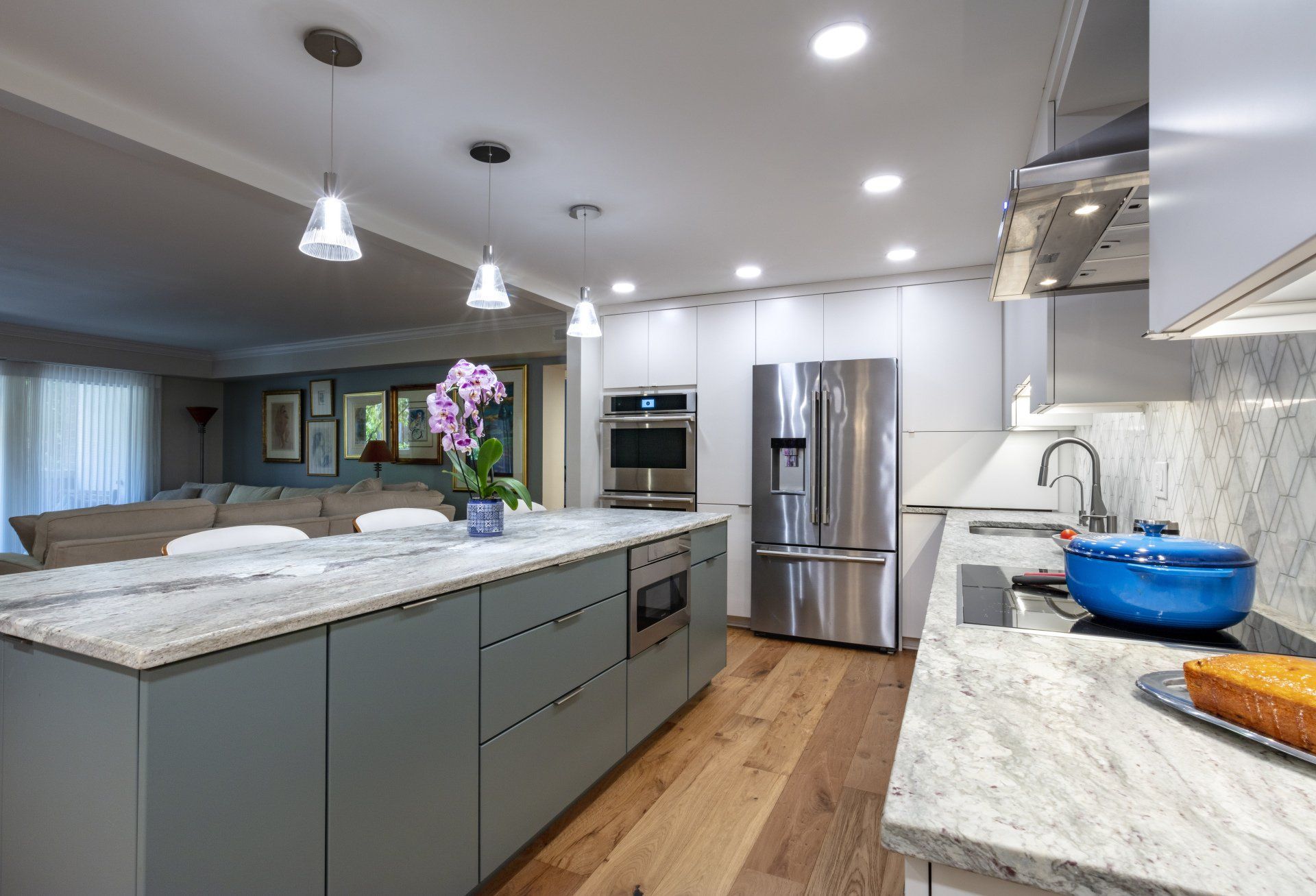 Modern kitchen with island, stainless steel appliances, white cabinets, and gray countertops