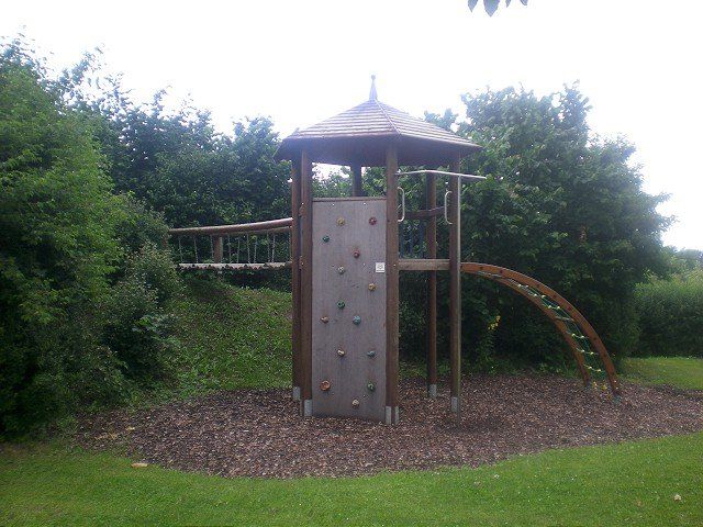 Ein Holzspielplatz mit Rutsche und Kletterwand