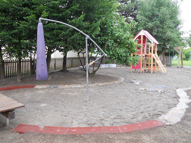 Ein Spielplatz mit Basketballkorb und Schaukeln