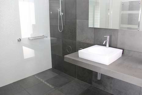 white sink next to updated shower tiling