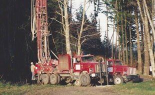 Well Drilling — Drilling Trucks In A Forest in Bow,WA Well Drilling — Drilling Trucks In A Forest in Bow,WA