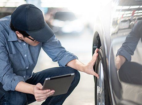 Auto Insurance Services — Man Checking Far Tire in Largo, FL Auto Insurance Services — Man Checking Far Tire in Largo, FL