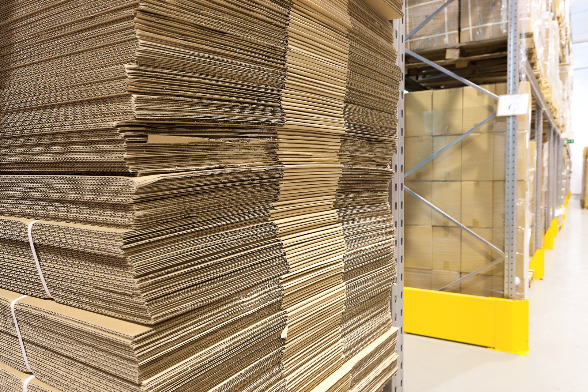A warehouse filled with lots of cardboard boxes stacked on top of each other.