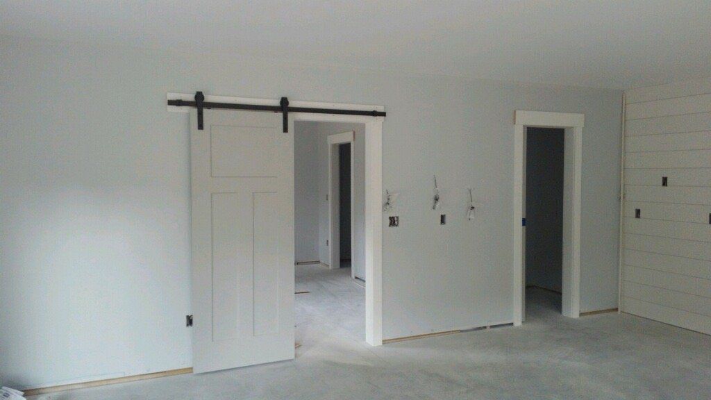 An empty room with white walls and sliding barn doors