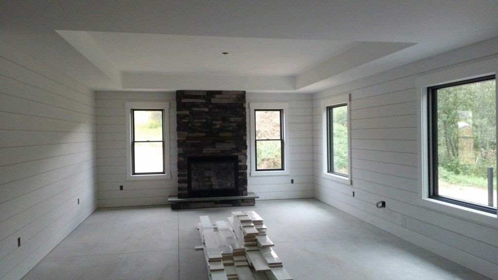 A living room with a fireplace and lots of windows
