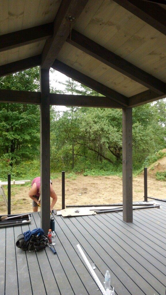A man is working on a deck under a roof