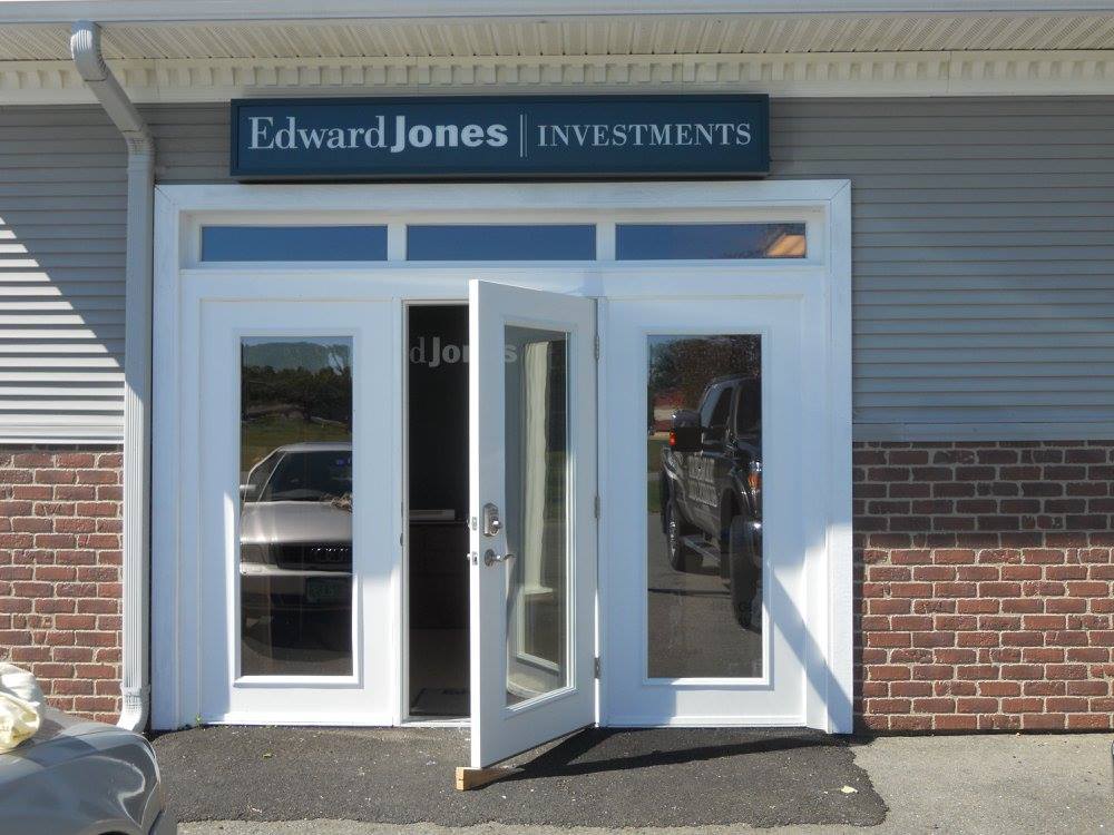 Edward Jones Investments storefront with white doors and a brick exterior, one door open
