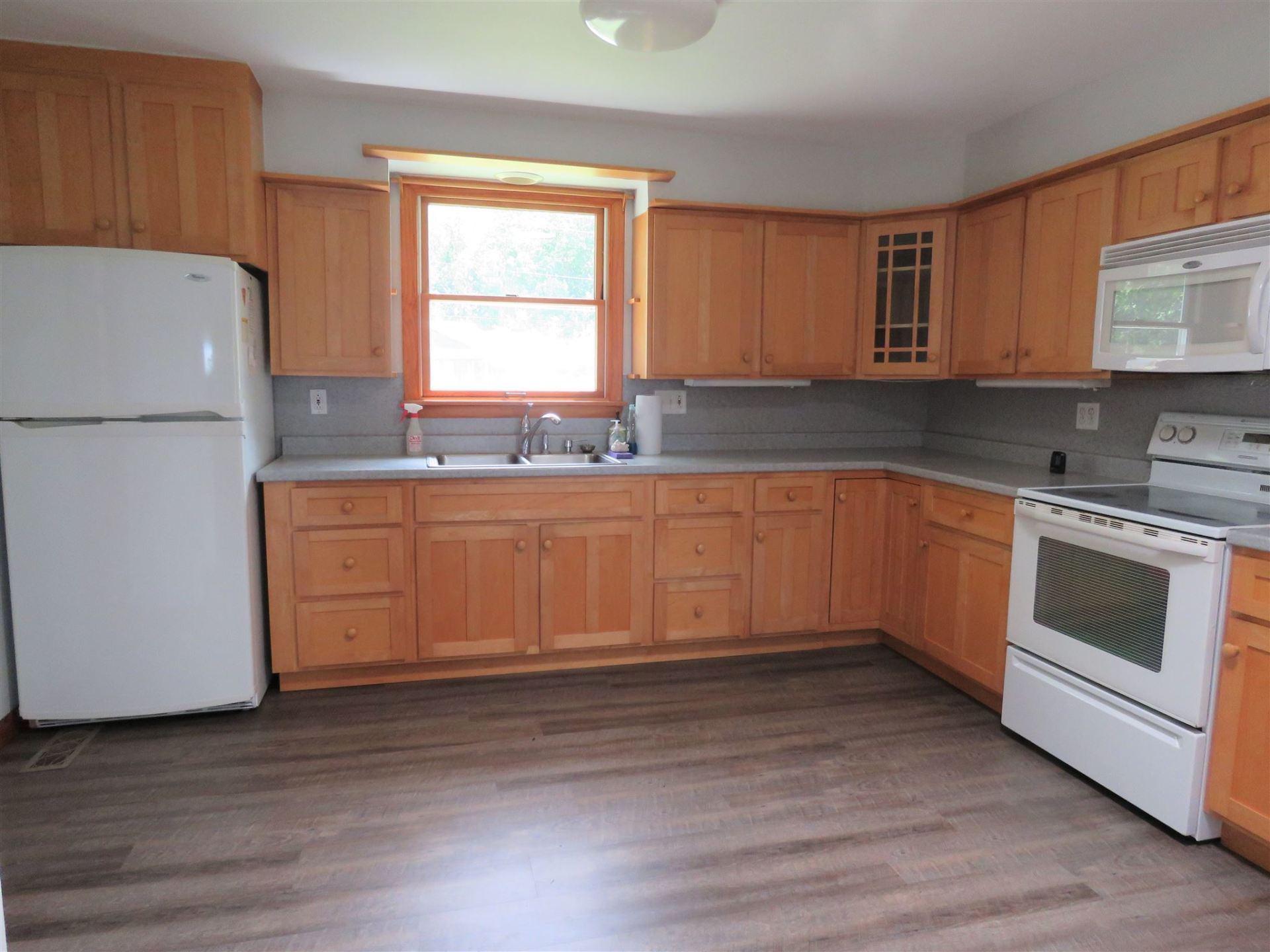 A kitchen with wooden cabinets and a white refrigerator