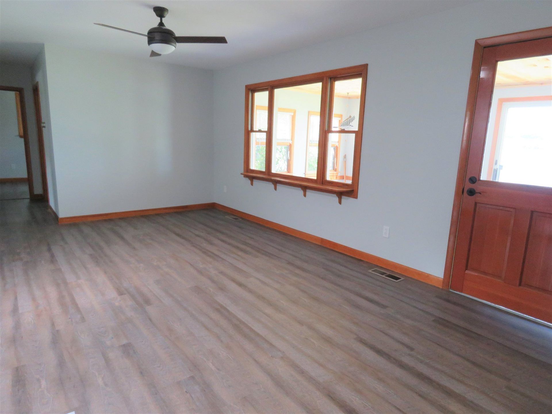 A living room with hardwood floors and a ceiling fan