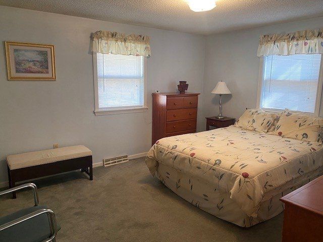 A bedroom with a large bed and a bench