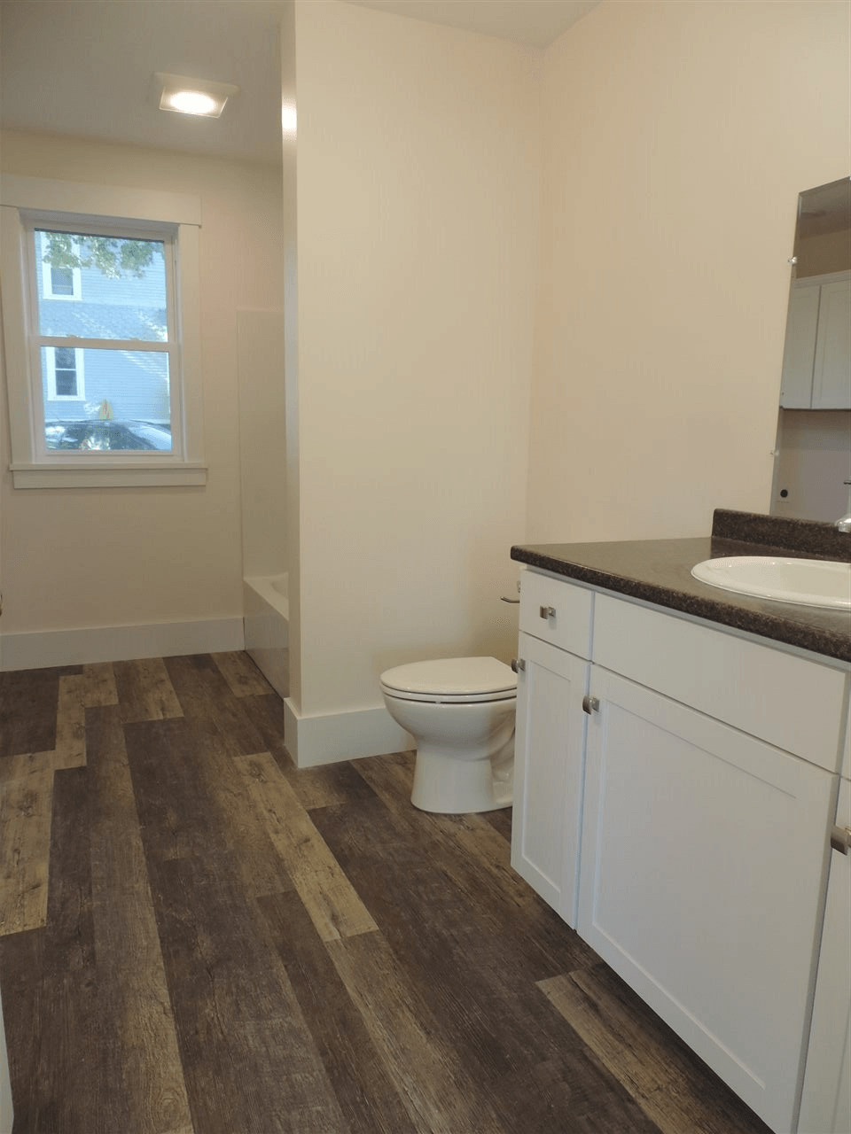 A bathroom with a toilet a sink and a window