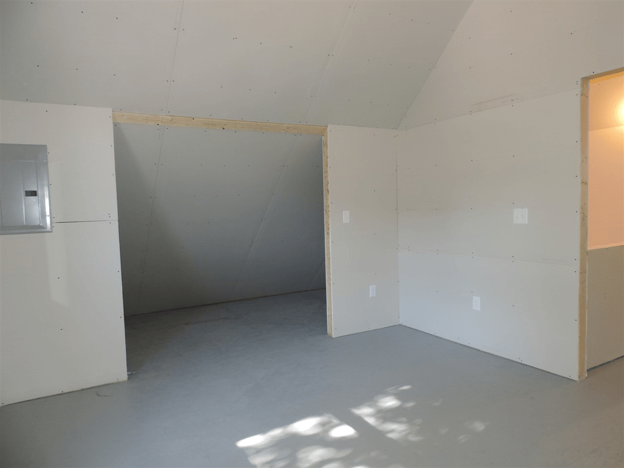 An empty room with white walls and a ceiling