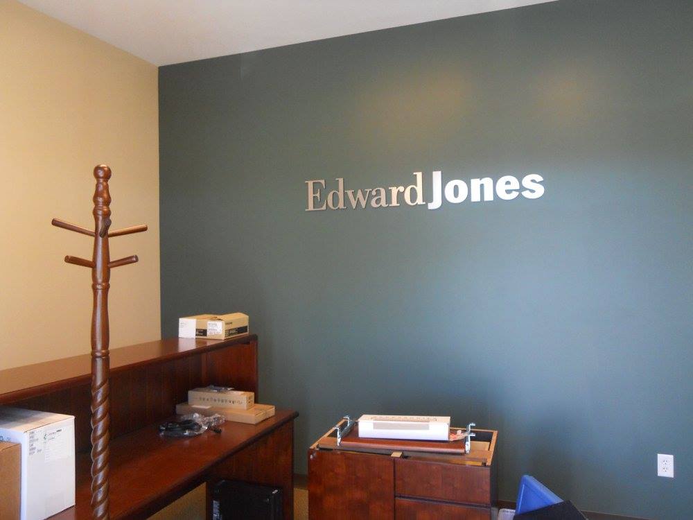 Edward Jones office with blue wall, wooden coat rack, desk, and chairs