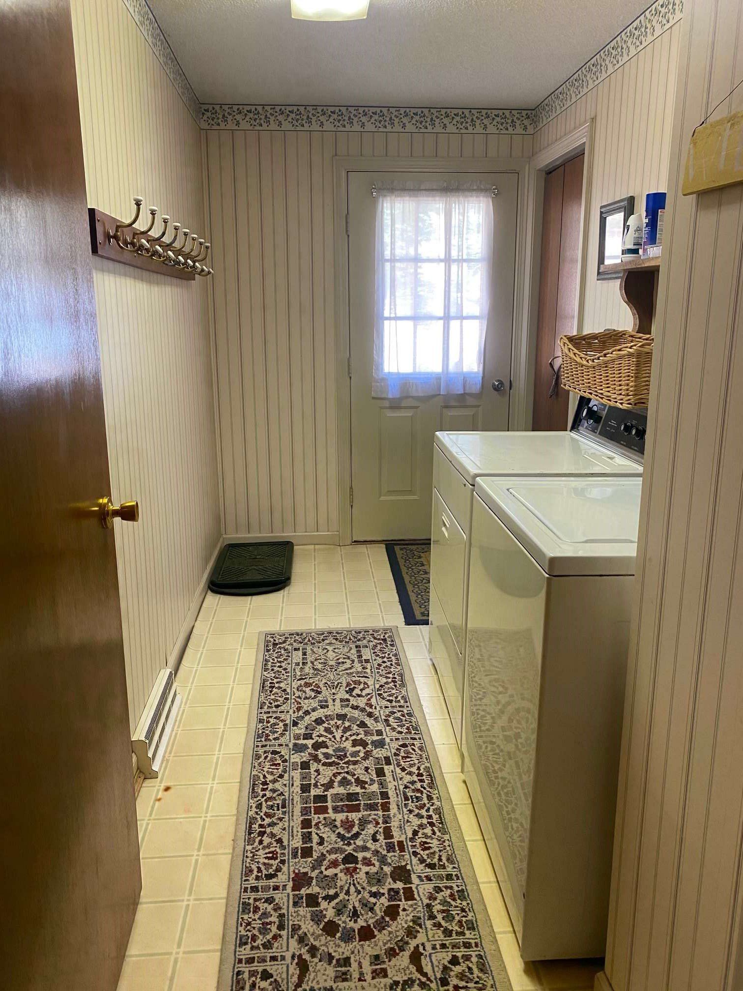 A laundry room with a washer and dryer and a door