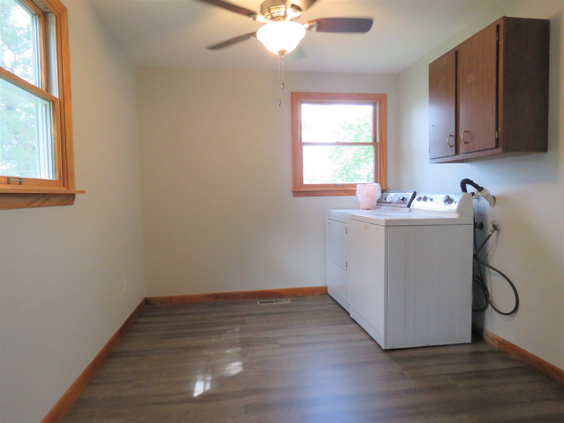 A laundry room with a washer and dryer and a ceiling fan