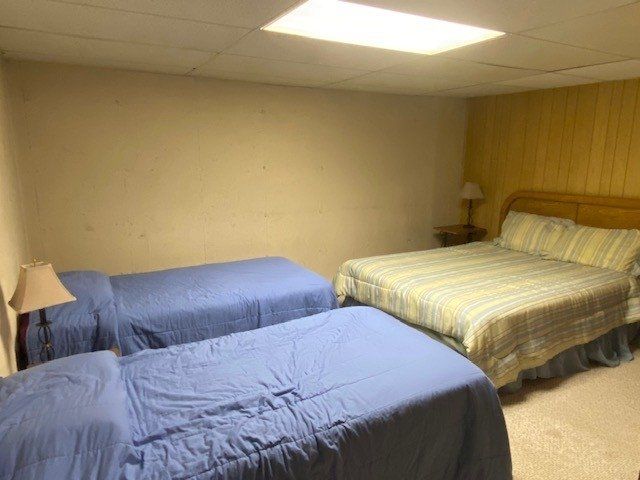 A bedroom with three beds and a large bed.