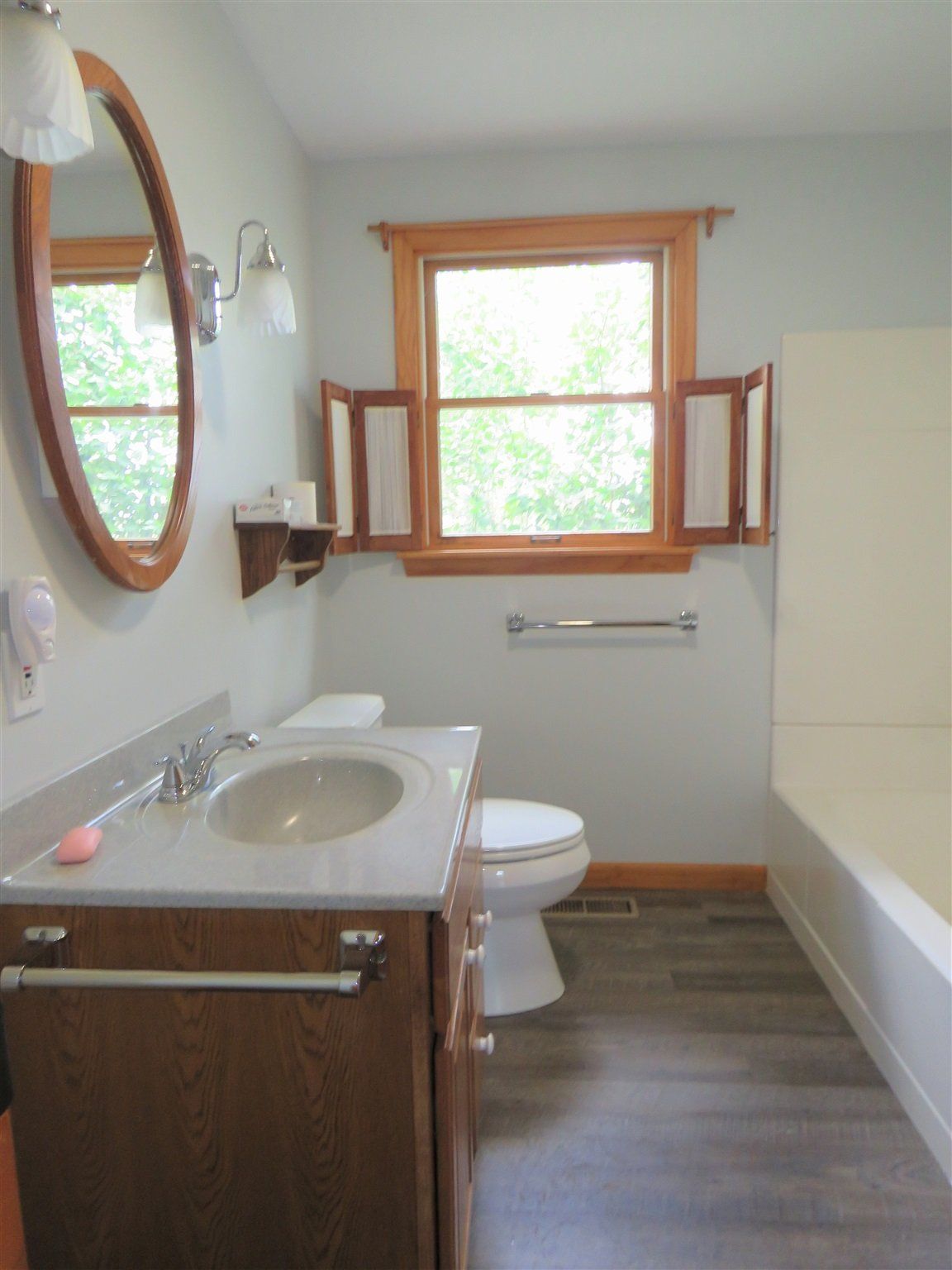 A bathroom with a toilet a sink and a mirror