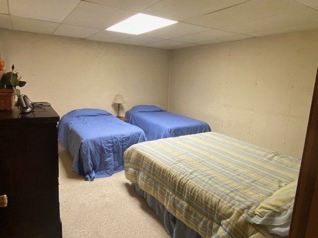 A bedroom with two beds and a dresser
