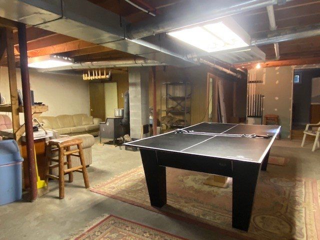 A basement with a pool table and a couch