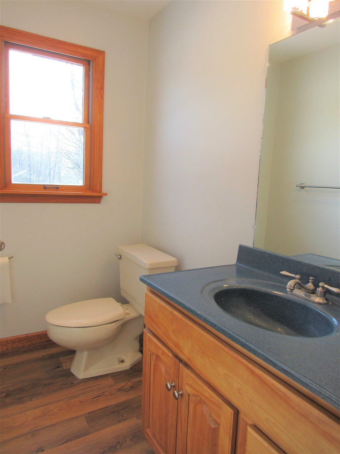 A bathroom with a toilet a sink and a window