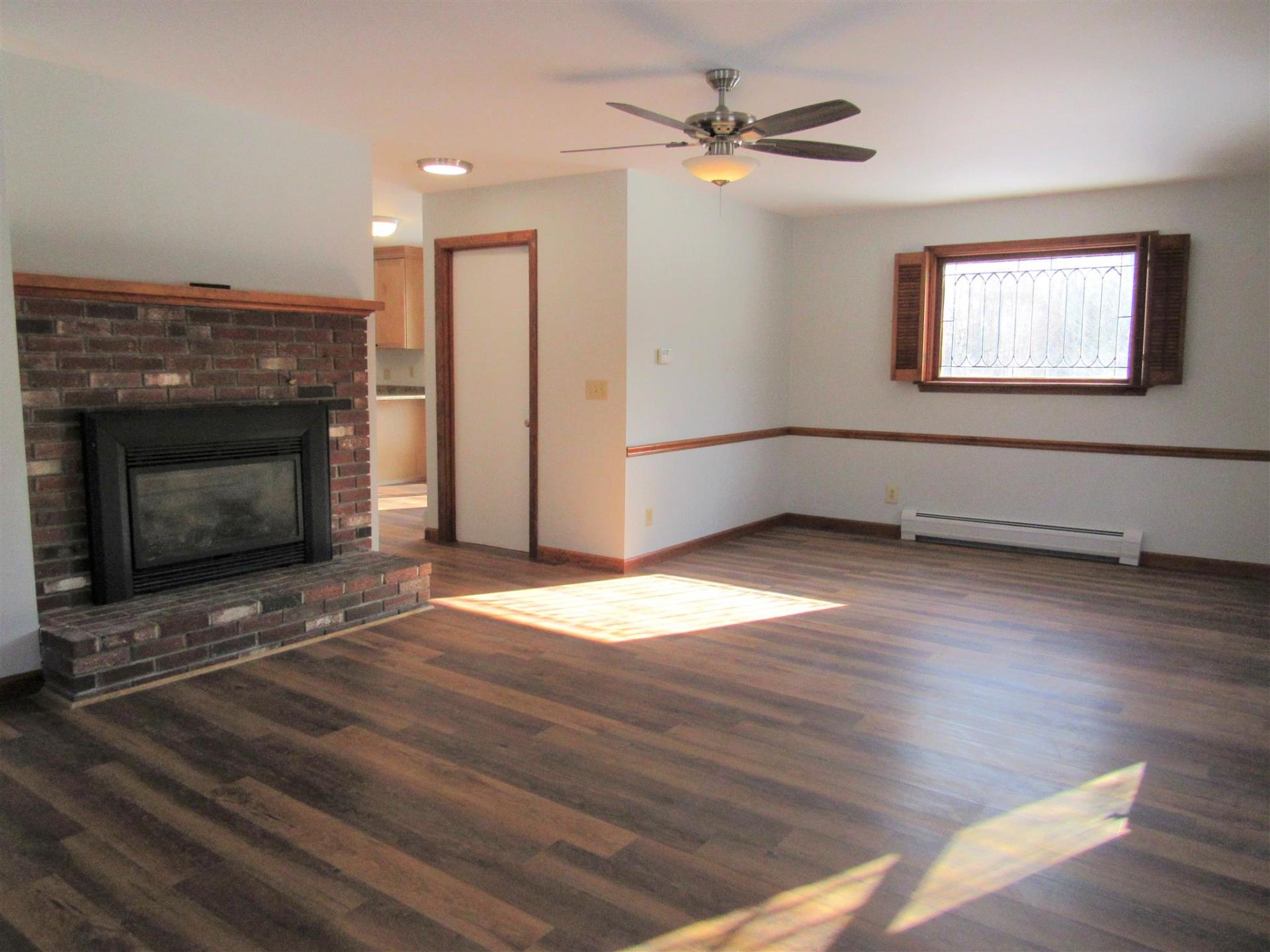 A living room with a fireplace and a ceiling fan