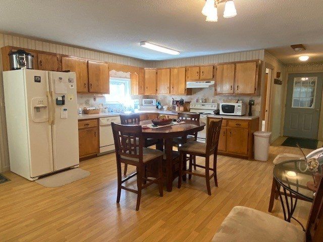 A kitchen with a table and chairs and a refrigerator