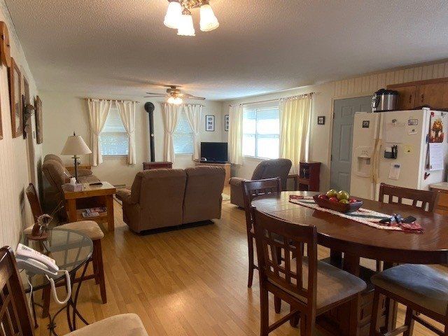 A living room with a table and chairs and a refrigerator