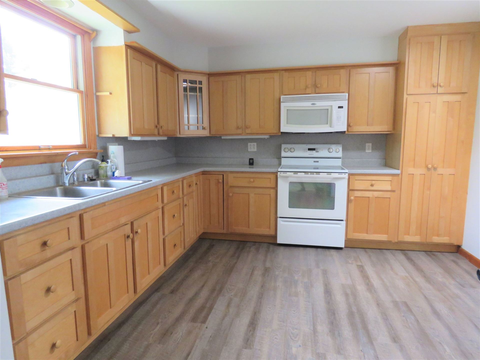 A kitchen with wooden cabinets and a white stove