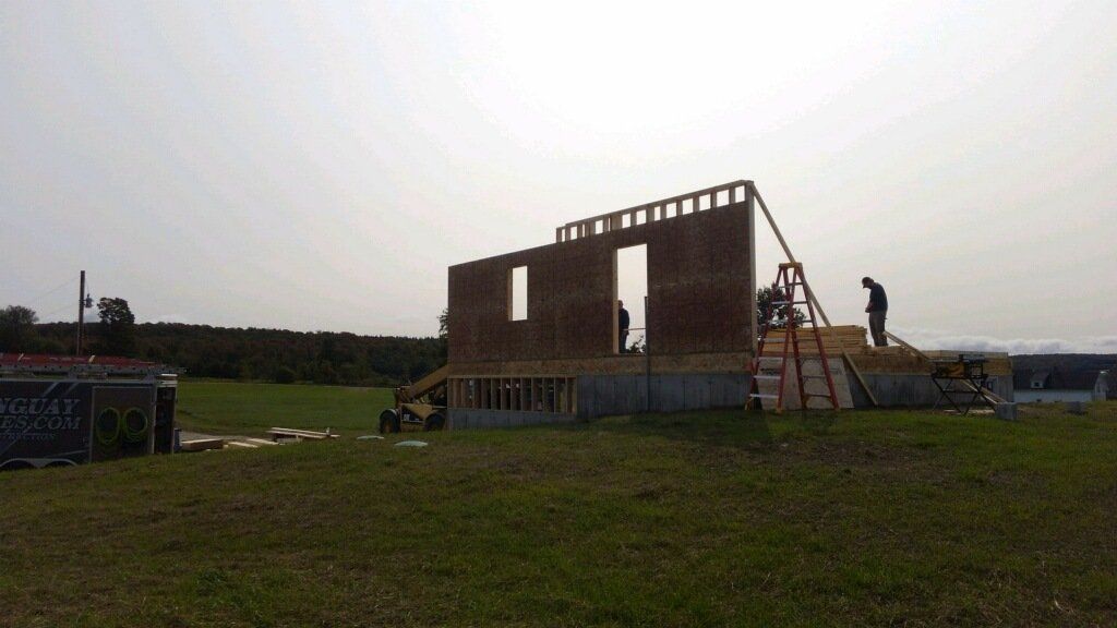 A large building is being built in a grassy field