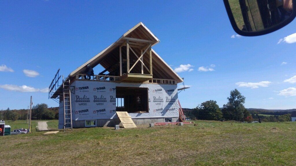A house is being built in the middle of a grassy field