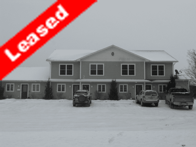 2577 Unit 2 Derby VT. Apartment house in the snow with vehicles park outside