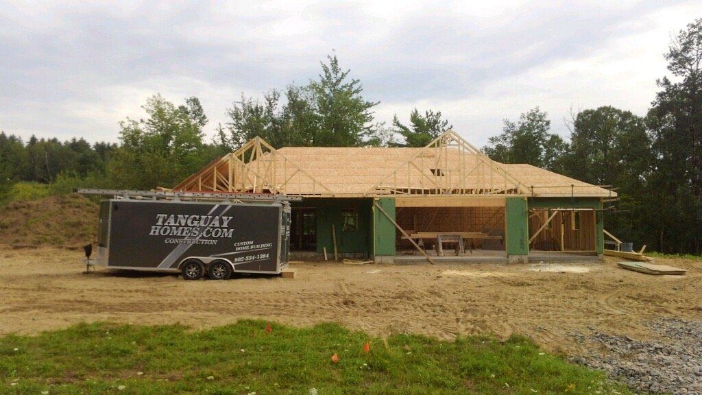 A trailer that says ' taylor ' on it is parked in front of a house under construction