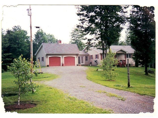 A picture of a house with two red garage doors