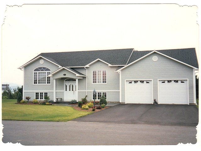 Suburban gray two-story house with attached two-car garage and paved driveway