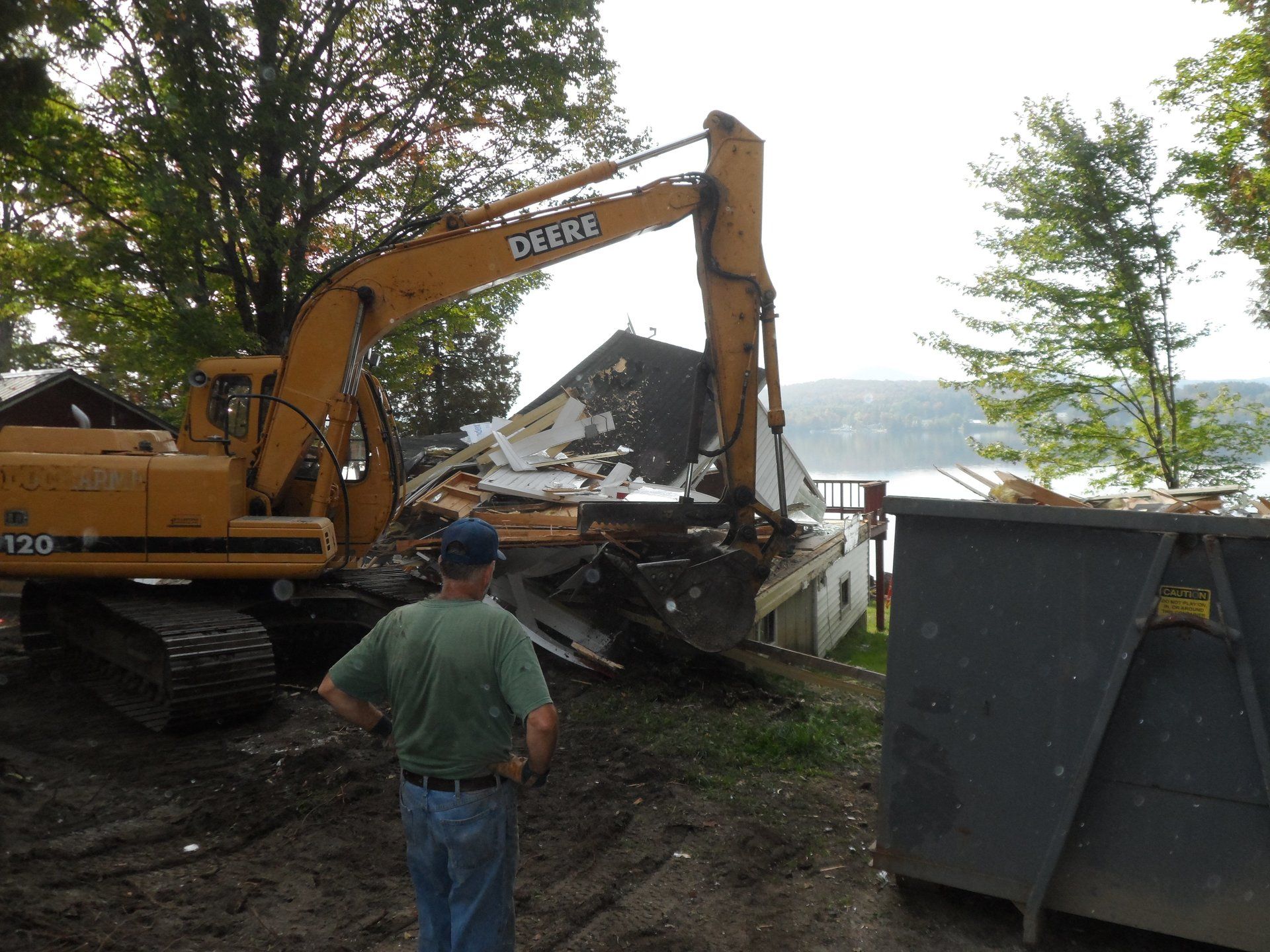 A man stands in front of a case excavator