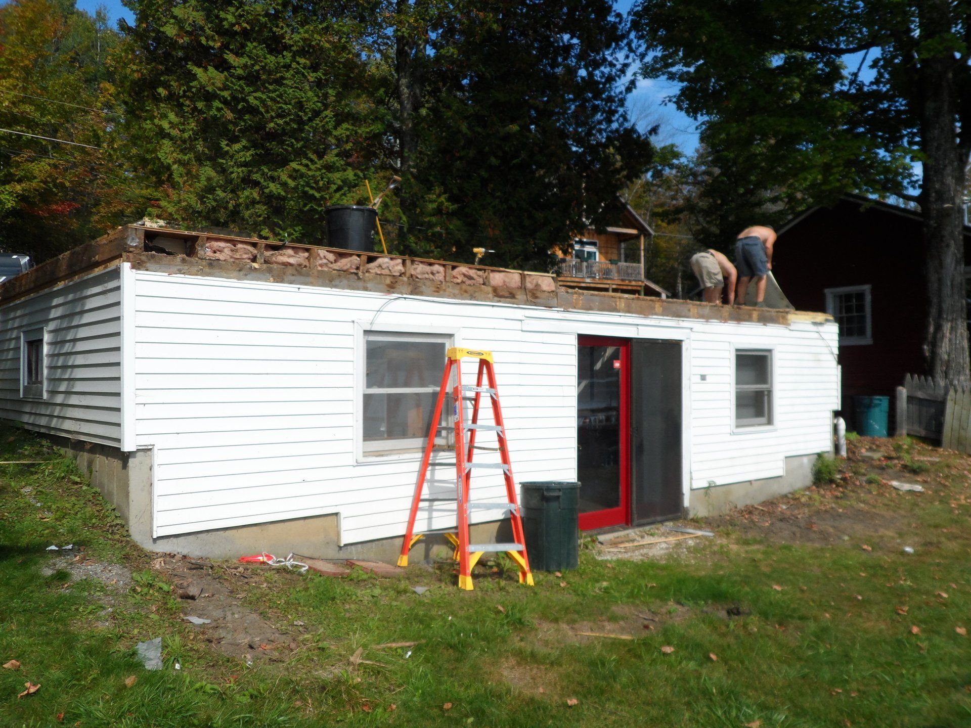 A ladder sits in front of a house that is being remodeled
