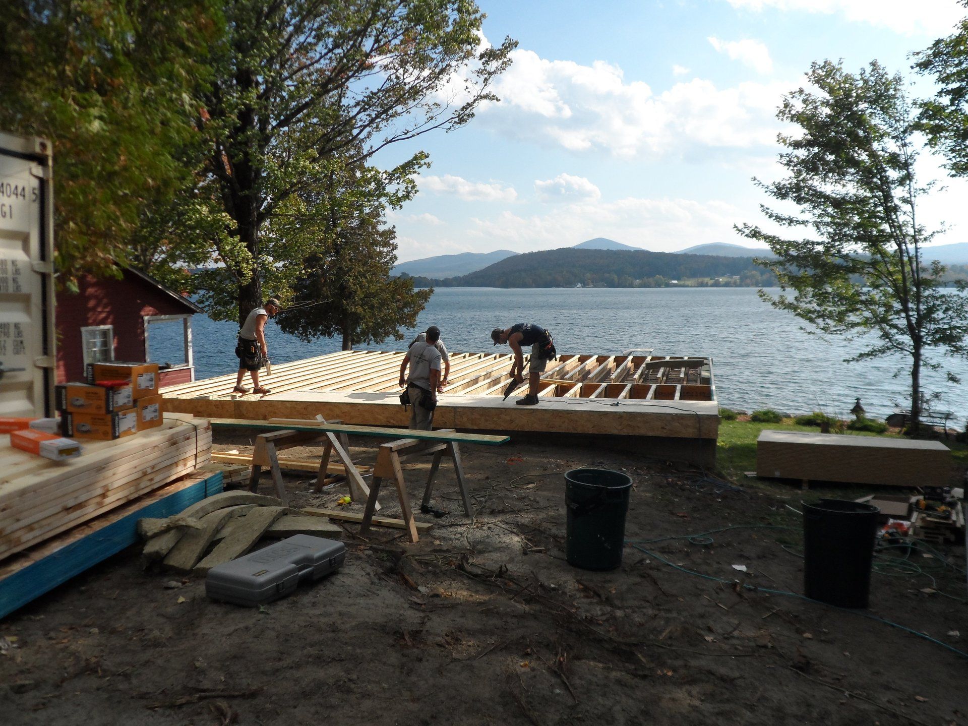 A group of people are working on a dock in front of a large body of water