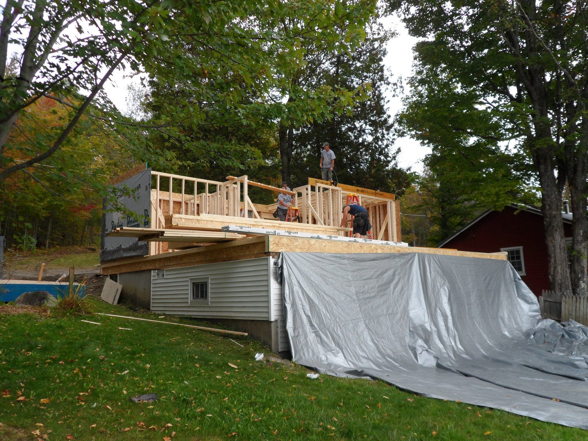 A house under construction with a tarp on the side of it