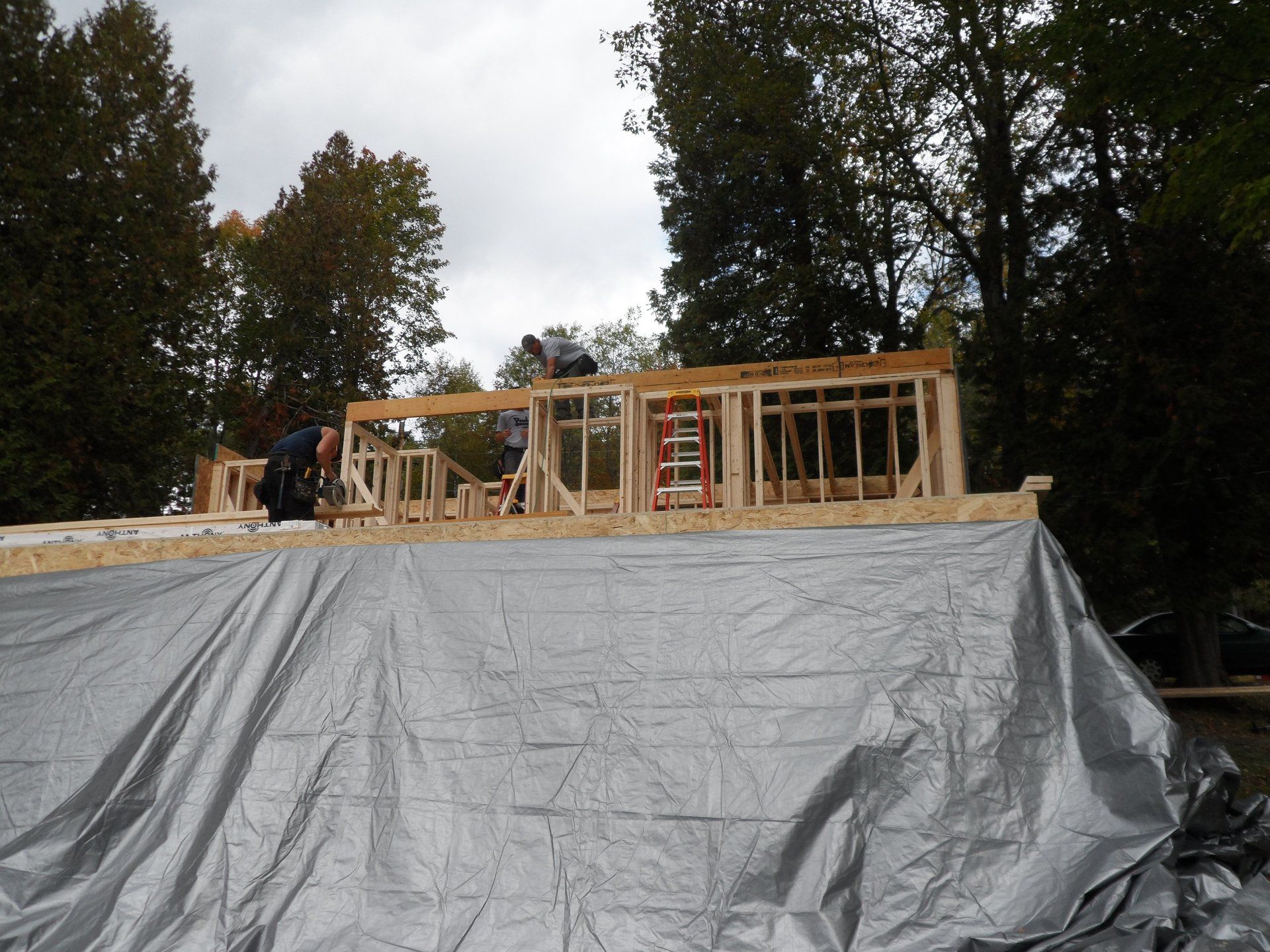 A large tarp is covering the roof of a building under construction