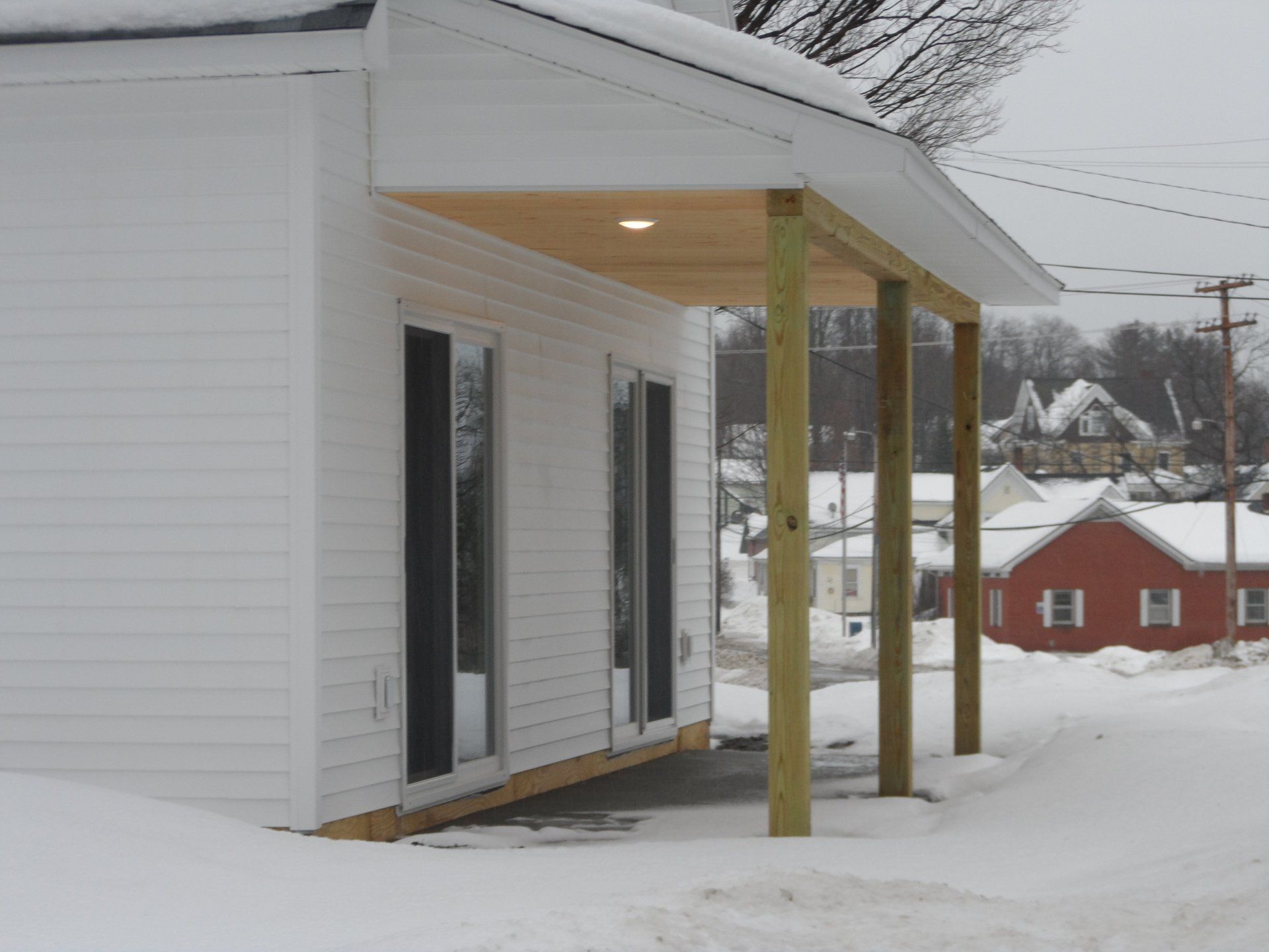 A white house with a porch in the snow