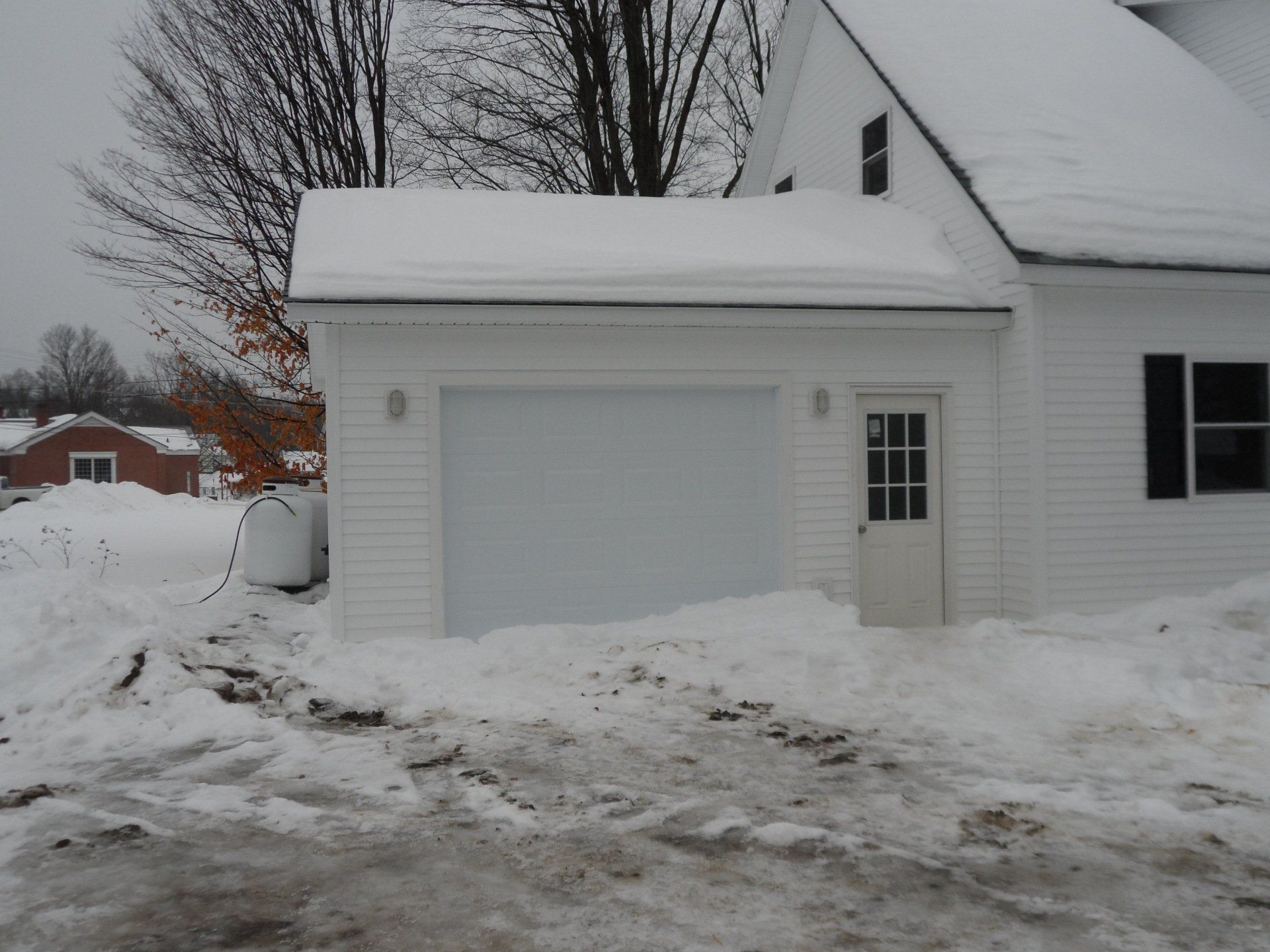 A white garage door is covered in snow