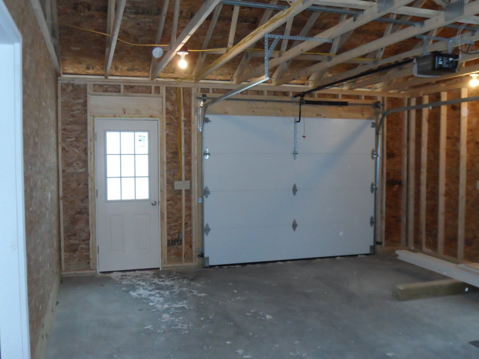 A garage under construction with a white garage door