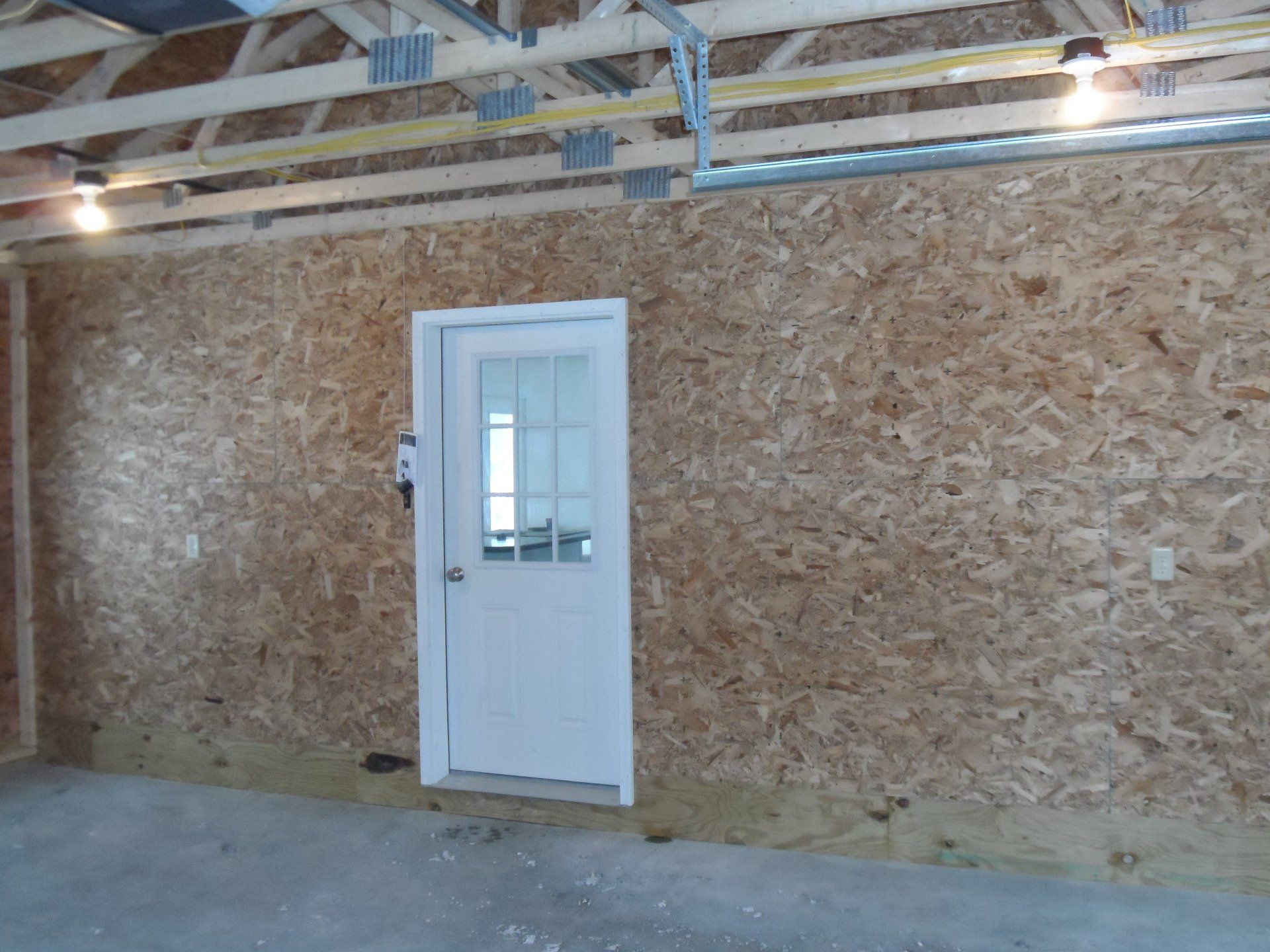 A white door in a room with a wooden wall