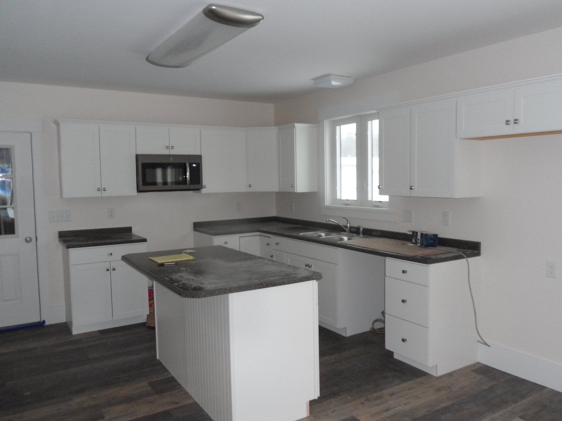 A kitchen with white cabinets and granite counter tops